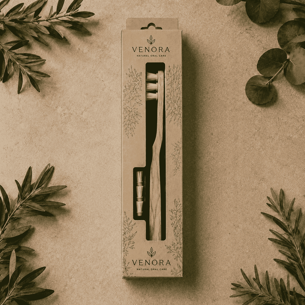 Venora toothbrush packaging on a beige background with green leaves